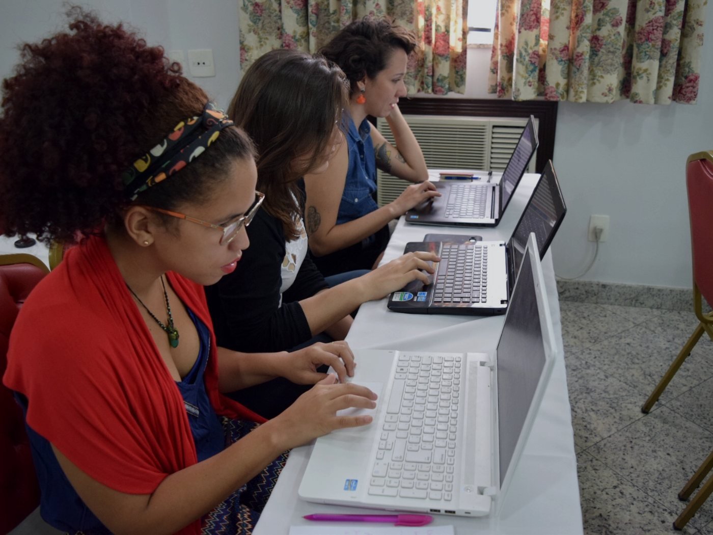 Mulheres diversas usando computadores em oficina no Rio de Janeiro